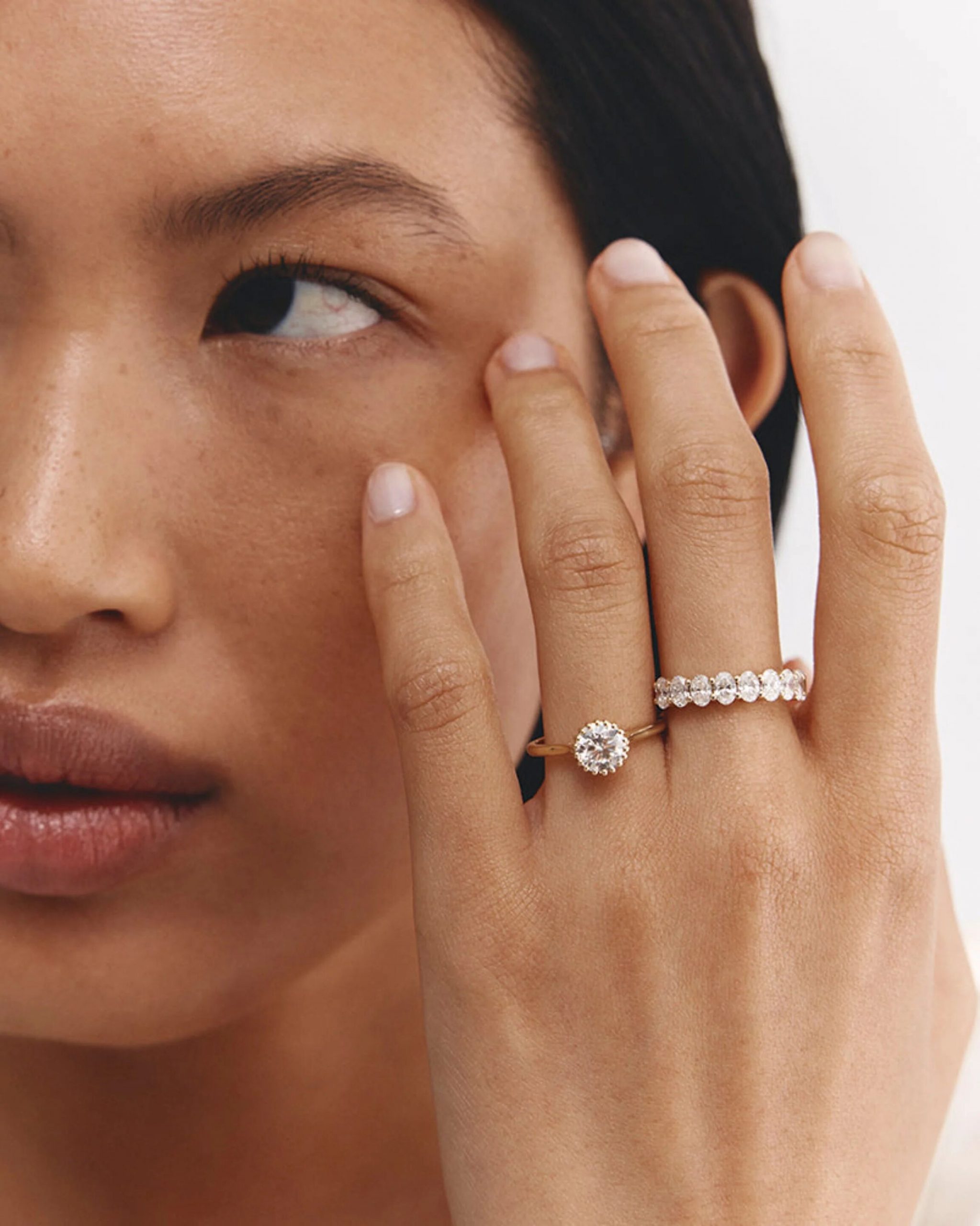 A close-up of a diamond ring on a person's hand.